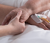 Eine Frau hält die Hand einer Patientin